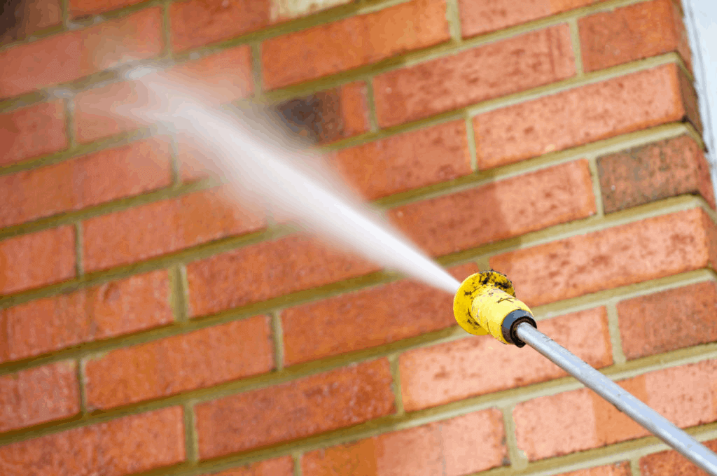 cleaning brick wall with power hose