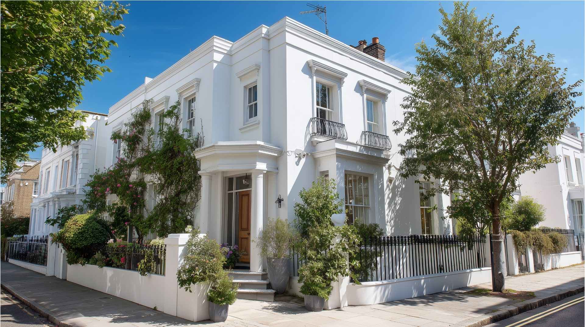 Elegant white Victorian-style home with lush greenery showcasing a clean painted exterior.
